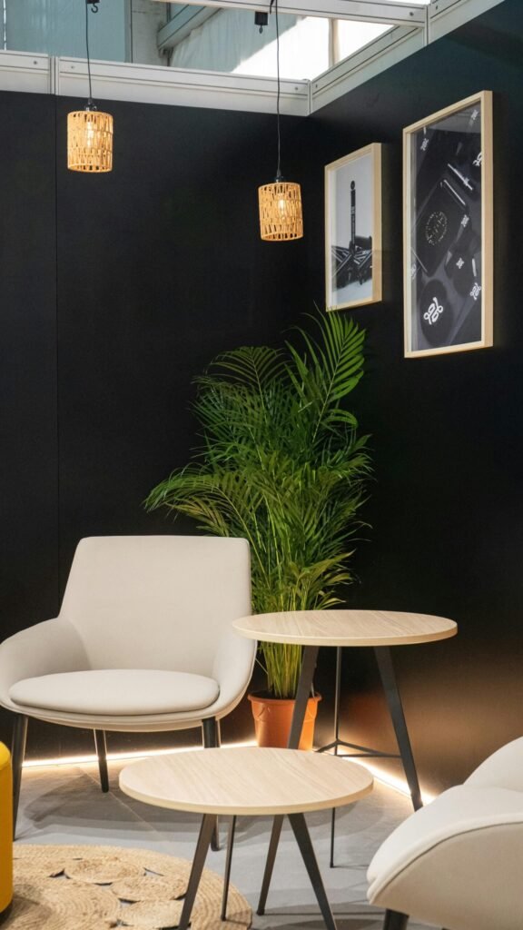 Mesa de recepción y muebles claros con helechos y pared oscura de fondo